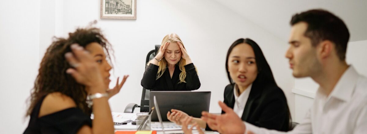Cheesy stock photo of 4 people embodying the term "stressful workplace"